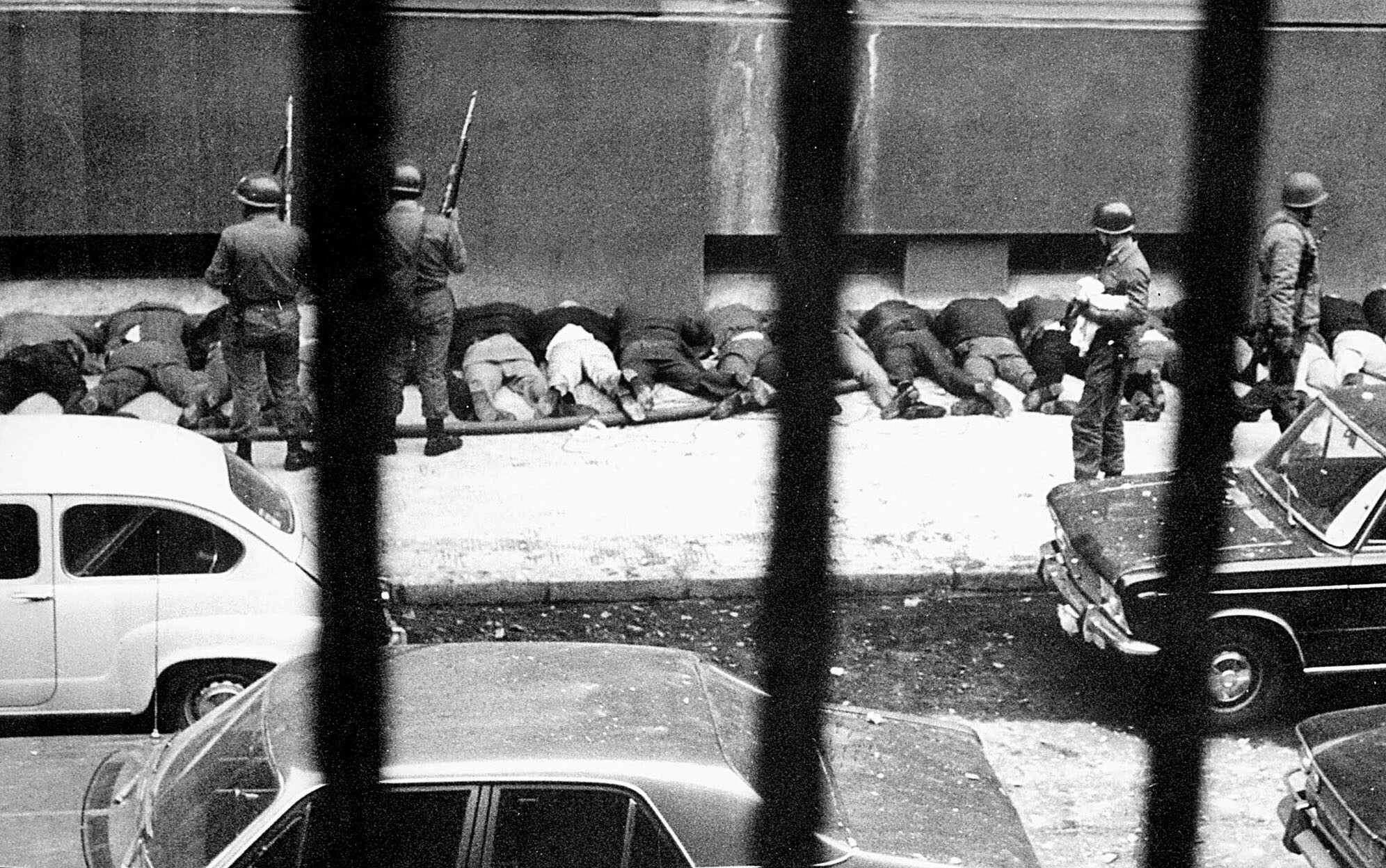 Empleados de&nbsp;La&nbsp;Moneda son obligados a&nbsp;acostarse en&nbsp;la&nbsp;acera tras ser detenidos por militares que tomaron el&nbsp;edificio durante el&nbsp;golpe de&nbsp;Estado contra el&nbsp;presidente Salvador Allende, el&nbsp;11&nbsp;de septiembre de&nbsp;1973.