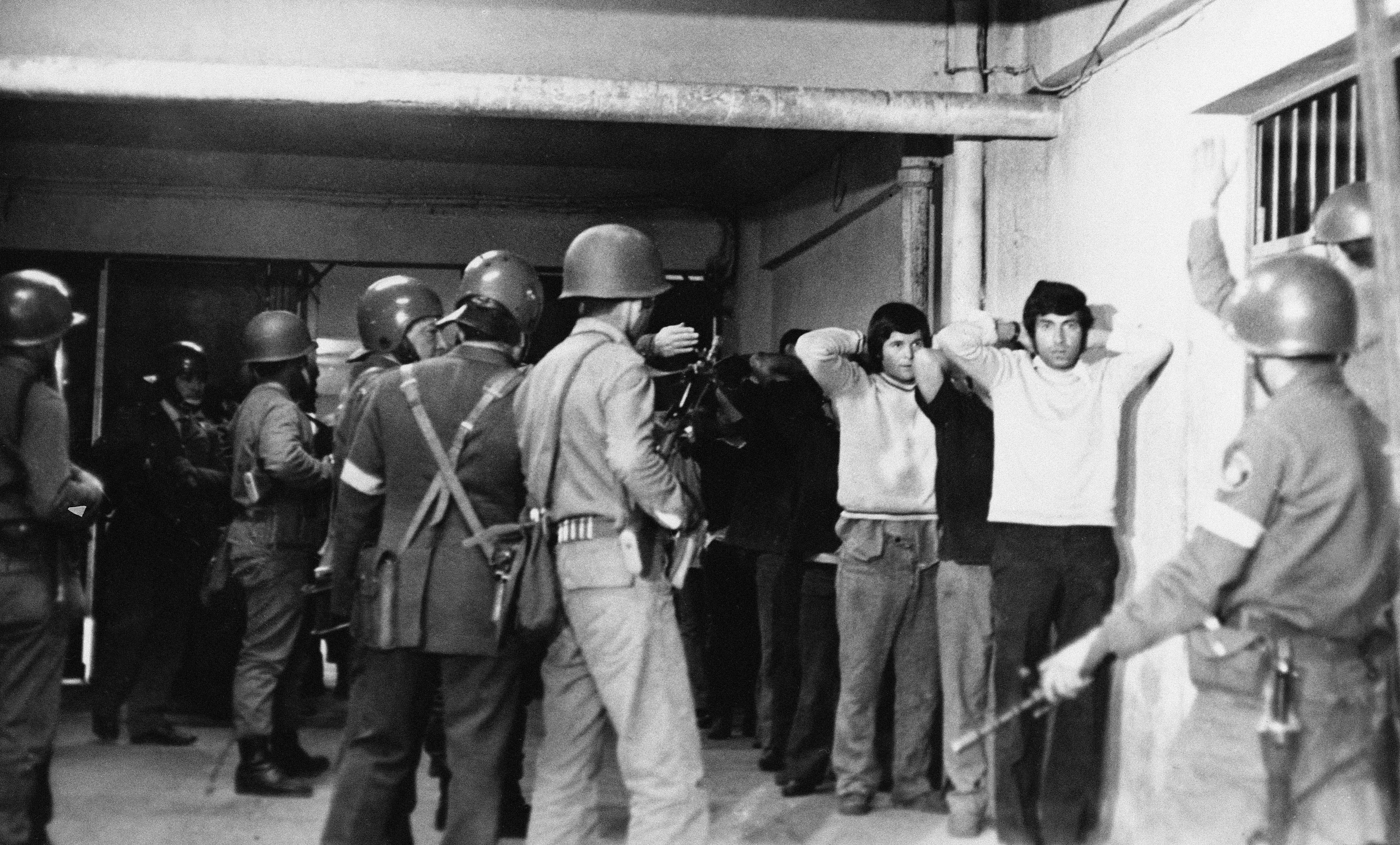 Polic&iacute;as y&nbsp;soldados vigilan a&nbsp;los presos reci&eacute;n llegados al&nbsp;Estadio Nacional de&nbsp;Santiago, el&nbsp;22&nbsp;de septiembre de&nbsp;1973. El&nbsp;recinto deportivo en&nbsp;esos d&iacute;as fue convertido en&nbsp;uno de&nbsp;los centros de&nbsp;tortura.